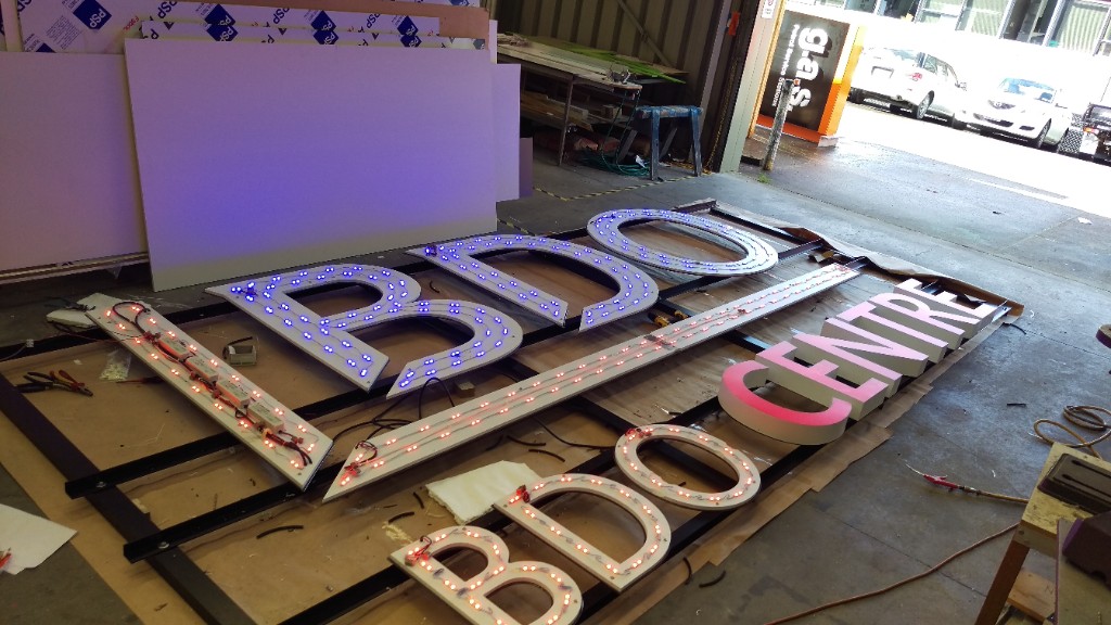 Large illuminated signage being assembled in a workshop